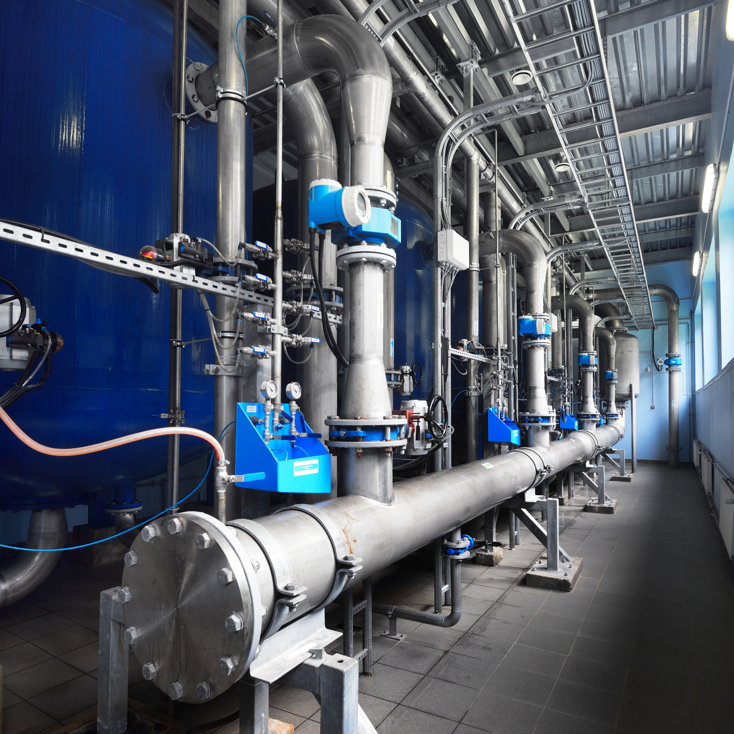 Large industrial water treatment and boiler room. Shiny pipes, pressure vessels, piping armateure